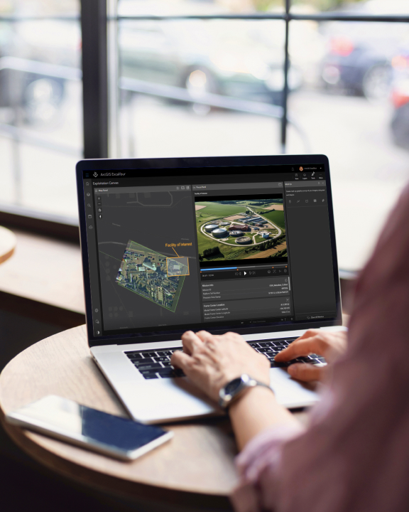 Analist die een tablet vasthoudt en typt terwijl hij video bekijkt in ArcGIS Excalibur