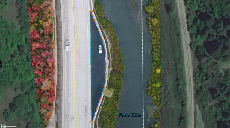 An aerial drone view of a highway near fall foliage and green trees