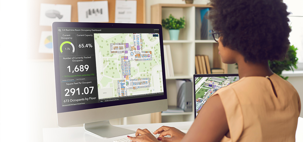 Woman working at a computer viewing indoor data with a dashboard with numbers and looking at indoor maps