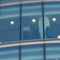 Outside looking into a large, multi-story office building window.