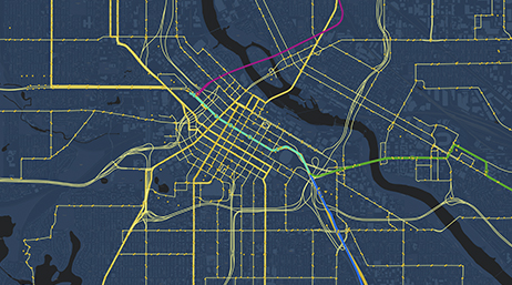 A dark grey map with roads depicted in yellow and transit lines in pink, green, and blue