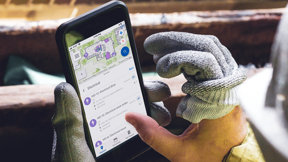 Maintenance worker holding a mobile phone showing an indoor map,Maintenance worker holding a mobile phone showing an indoor map