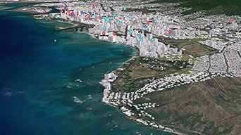 An aerial view of Honolulu, Hawaii, with many multicolored dots marking the tall buildings in the distance