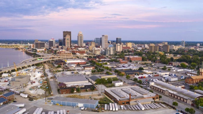 An aerial view of an urban city with buildings, a bridge, and a body of water