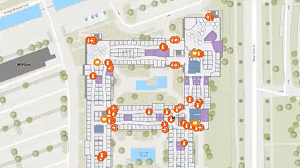 A digital map with white roads, green trees, and scattered orange data points