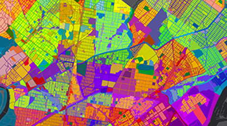 A bright multicolored street map with neighborhoods highlighted in green, yellow, and orange and boundary lines in blue