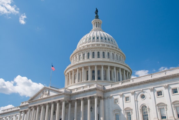 A photo of the US Capitol building against a clear sunny blue sky
