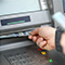 A hand pulling $100 bills out of an ATM