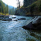 Person standing along the banks of a stream