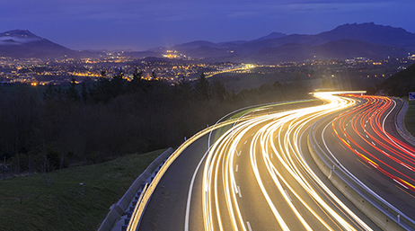 A time lapse of a busy interstate with streaks of white and red lights on either side