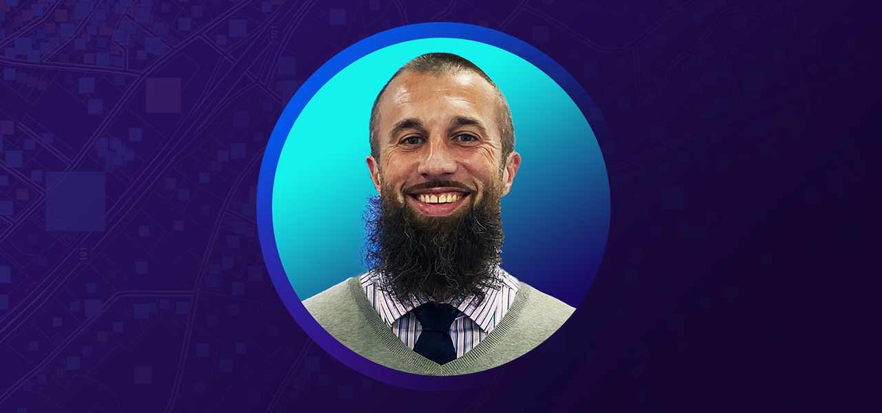 Thomas Matich wearing business attire and smiling overlaid on a blue and purple background 