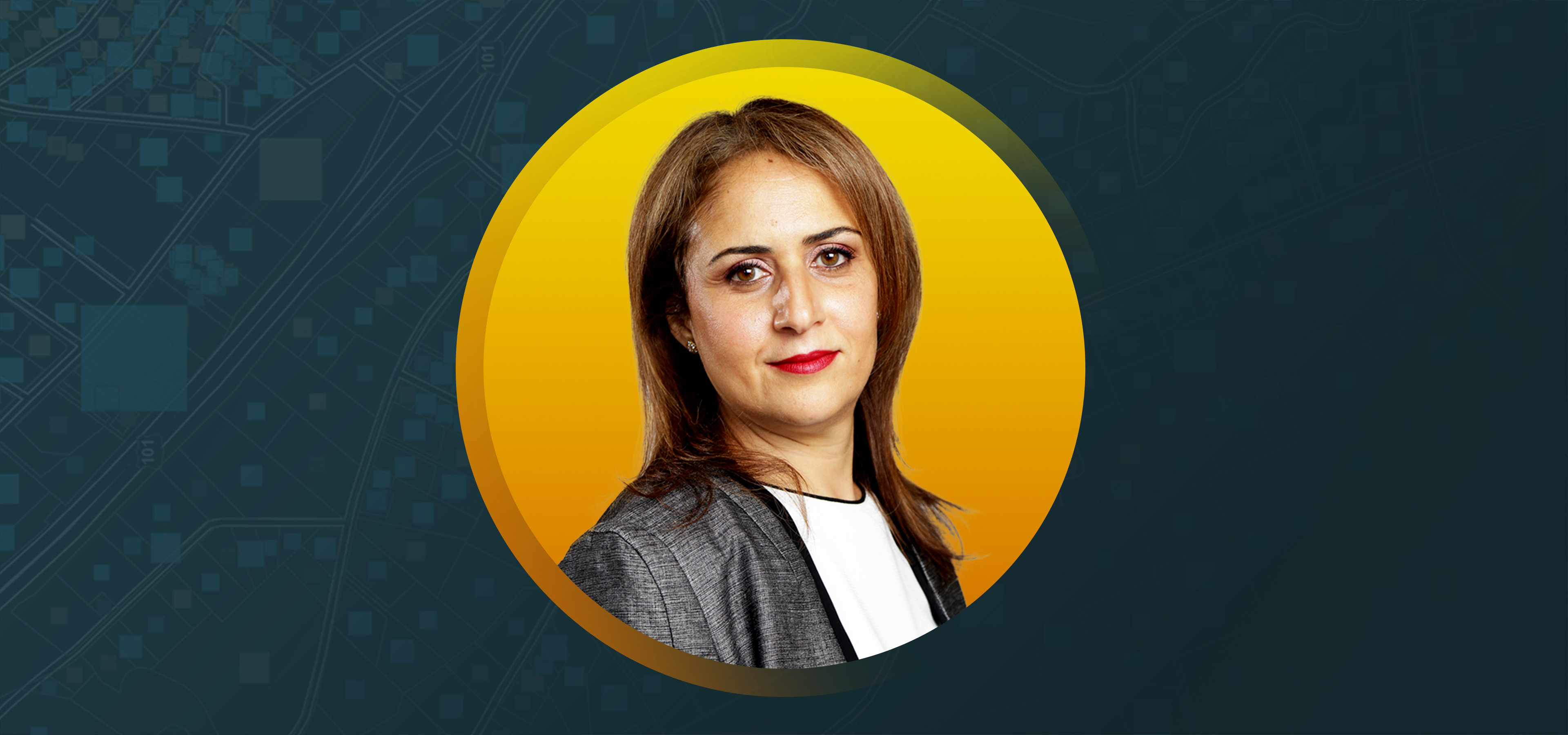 Portrait of Manal Sayed smiling in a gray blazer against a gold background in a round border