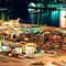 A sea shipping port with many containers and cranes lit at night