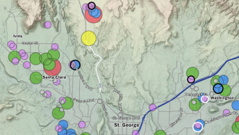 A gray contour map dotted with colorful circles denoting population concentrations