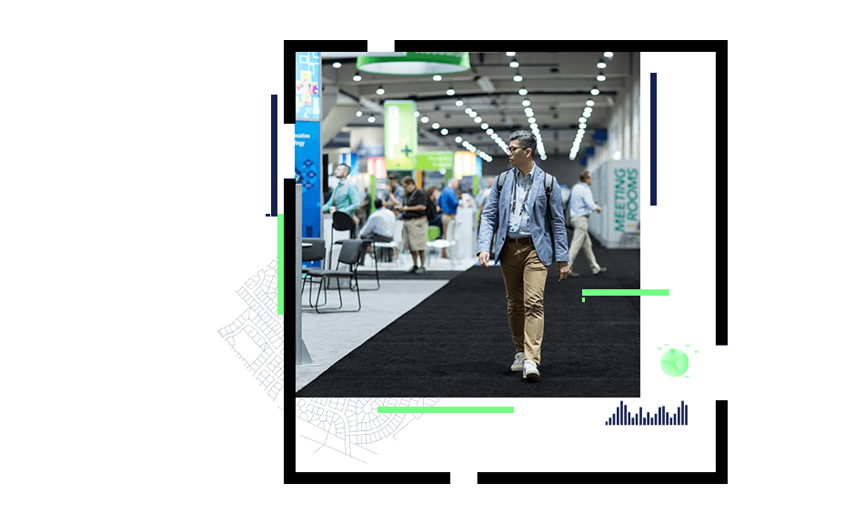 A photo of a person wearing a blazer and a backpack walking through a brightly-lit conference exhibit hall