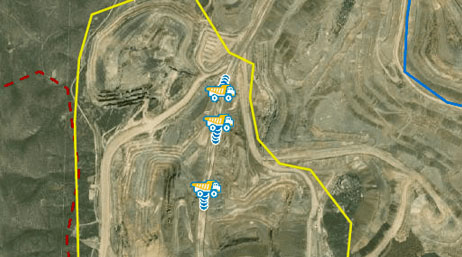 •	An aerial view with a yellow line around mining operations and illustrated mining trucks showing the real-time fleet tracking that helps reduces driving and idle time