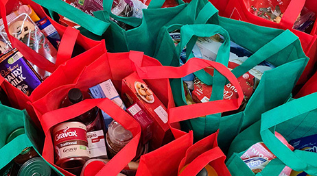 A photo of the tops of ten full blue and red grocery bags crowded together
