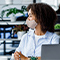 A group of casually dressed people wearing cloth and paper face masks having a discussion in a brightly lit conference room