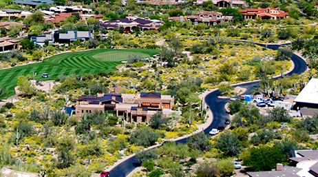An aerial photo of a green tree-filled golf course with an artificial river winding through the center