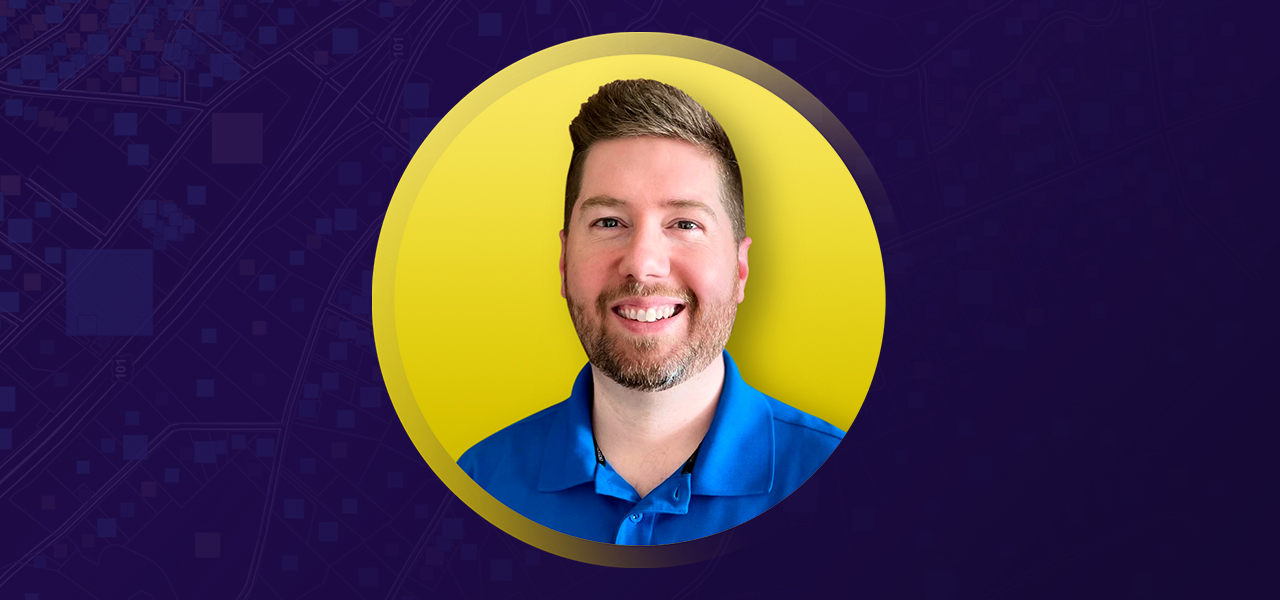 Portrait of Casey Randolph smiling in a royal blue collared shirt