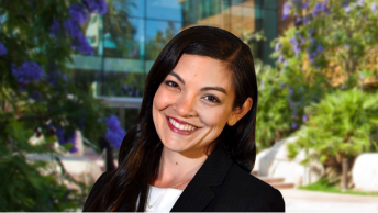 Portrait of Michelle Tateyama smiling in a dark suit and white blouse