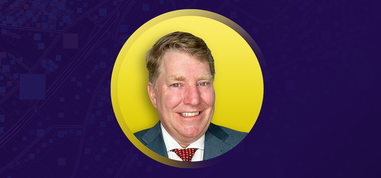 Portrait of Scott Minter smiling in a blue suit and tie