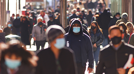 A sidewalk with crowds of people walking