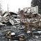 A burned down structure, chair, and charred ground from a fire in California