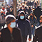 A sidewalk with crowds of people walking
