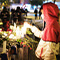 A person standing in lighting a candle at a makeshift memorial for people lost in an earthquake