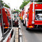 The side of a parked ambulance and the back of parked fire trucks