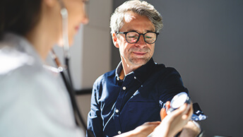 A person measuring another person’s blood pressure