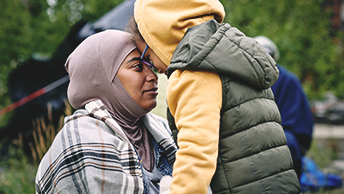 A woman and child with their foreheads pressed together as they look at each other