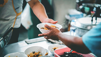 A person passing food to another person