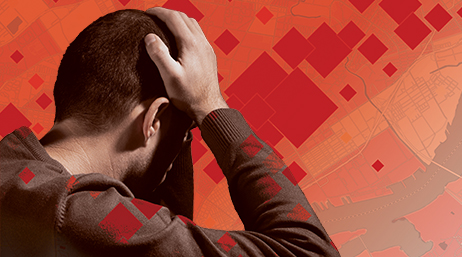 A composite image of a person holding their hands to their head as if in pain, with a red-toned city map in the background 