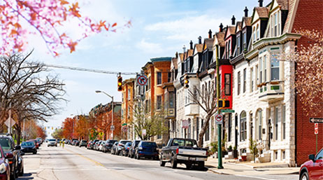 A street lined with cars and apartments