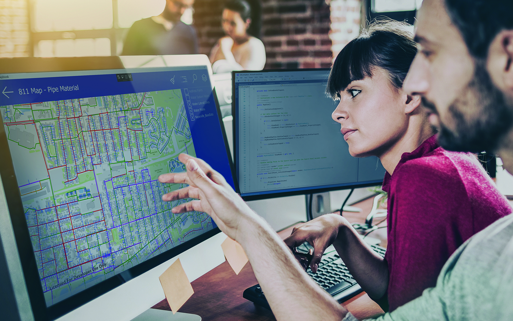 A GIS expert giving advice to business people using sticky notes and a gridded map 