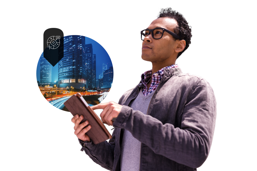 A casually dressed person using a tablet, overlaid with a small image of a brightly lit city at night in shades of blue and gold, against an abstract white and gray background